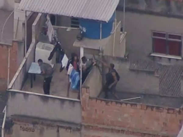 Homens armados tentam fugir durante operação da polícia em telhado no Jacarezinho, Zona Norte do Rio — Foto: Reprodução/TV Globo