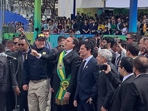 Com uma batuta na mão, Bolsonaro simula reger a banda militar que tocou no desfile de 7 de Setembro — Foto: Luiz Felipe Barbiéri / G1.