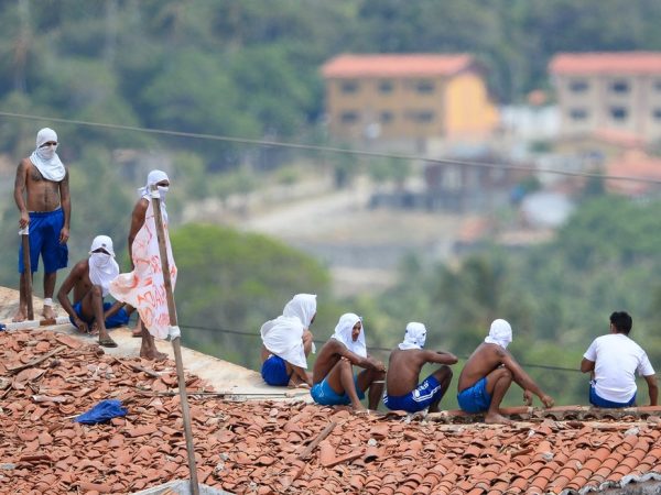 Presos são vistos no telhado da penitenciária de Alcaçuz, no Rio Grande do Norte, durante rebelião — Foto: Andressa Anholete/AFP