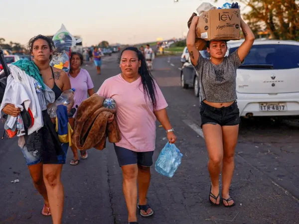 People walk carrying donated items in Eldorado do Sul, in Rio Grande do Sul, Brazil, May 6, 2024. REUTERS/Amanda Perobelli