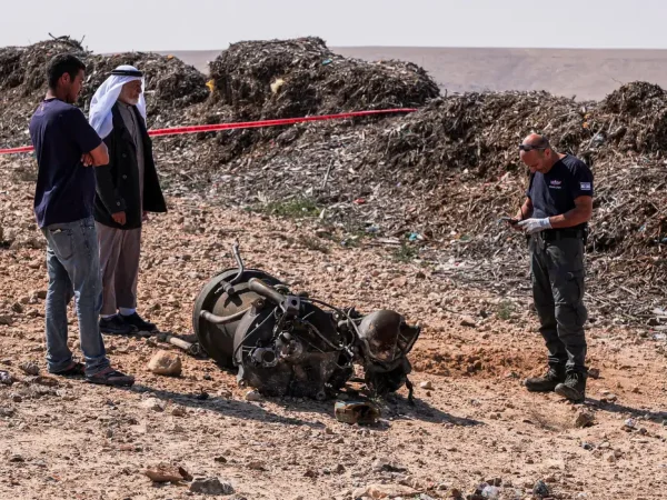A police officer and residents inspect the remains of a rocket booster that, according to Israeli authorities critically injured a 7-year-old girl, after Iran launched drones and missiles towards Israel, near Arad, Israel, April 14, 2024. REUTERS/Christophe van der Perre