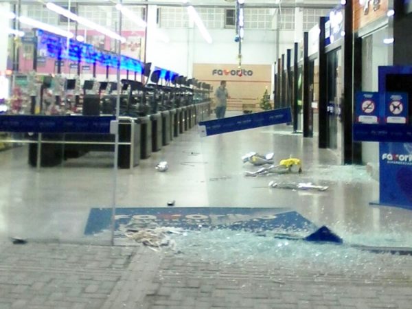 Bandidos quebraram as vidraças do supermercado e também saquearam várias lojas (Foto: PM/Divulgação)