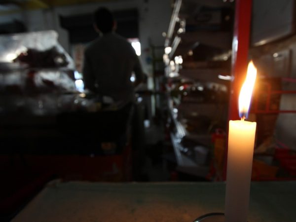 Mercadinho no Recife funciona com luz de velas após apagão (Foto: Guga Matos/JC Imagem/Estadão Conteúdo)
