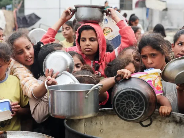 Palestinos aguardam para receber comida preparada por uma cozinha comunitária, em Nuseirat, Faixa de Gaza
08/04/2025
REUTERS/Ramadan Abed