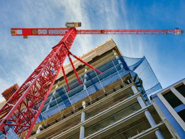 Um guindaaste vermelho na frente de um prédio em obras