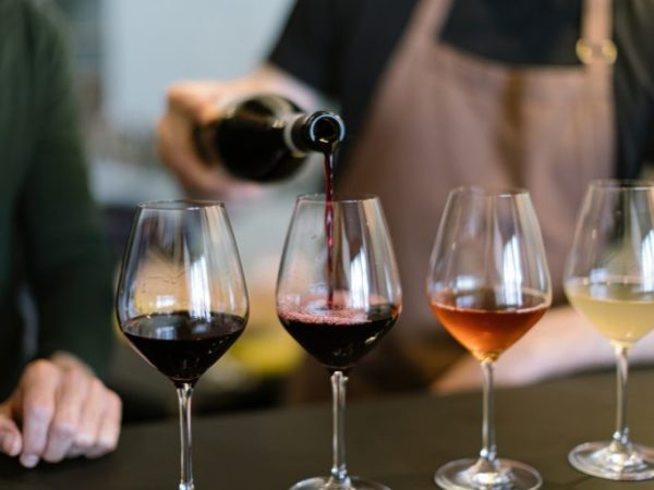 Quatro taças em cima da mesa com diferentes tipos de vinho
