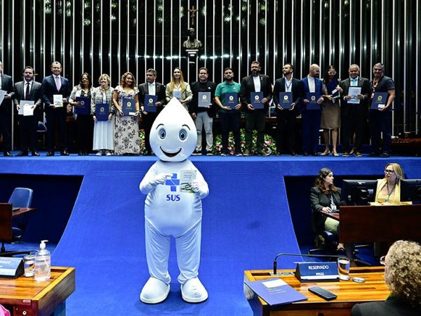 Zé Gotinha posa para foto com parlamentares e convidados.