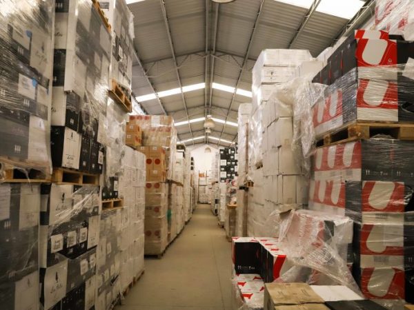 Galpão de armazenamento com muitas caixas empilhadas, embaladas para envio