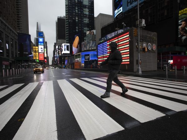 Homem atravessa rua vazia perto da Times Square, em Nova York, em meio à pandemia do novo coronavírus nos EUA — Foto: Mark Lennihan/AP