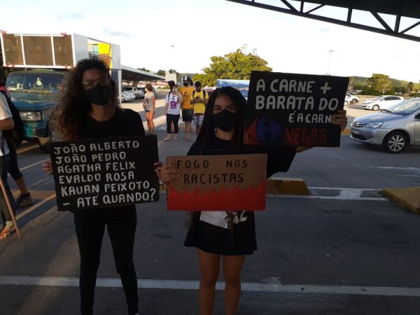 Jovens exibem cartazes em protesto antirracista em estacionamento do Carrefour em Natal — Foto: Julianne Barreto/Inter TV Cabugi