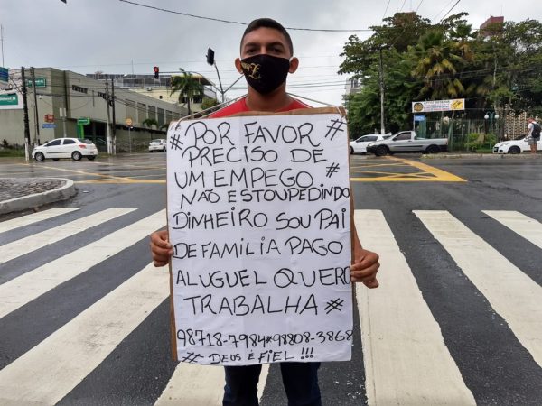 Jovem segura cartaz no cruzamento da Salgado Filho com a Antônio Basílio — Foto: Lucas Cortez/Inter TV Cabugi
