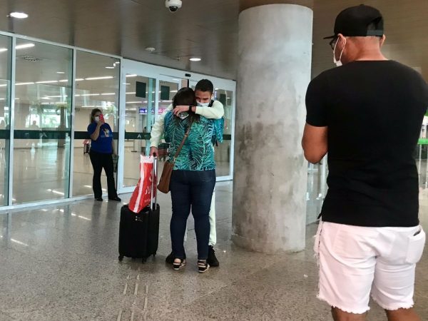 Jogador Edson Fernando, de 23 anos, abraça a mãe após desembarcar no Aeroporto de Natal — Foto: Ayrton Freire/Inter TV Cabugi