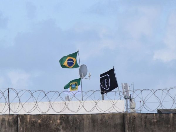 Agentes hasteiam bandeiras do Brasil e do RN em Alcaçuz (Foto: Fred Carvalho/G1)